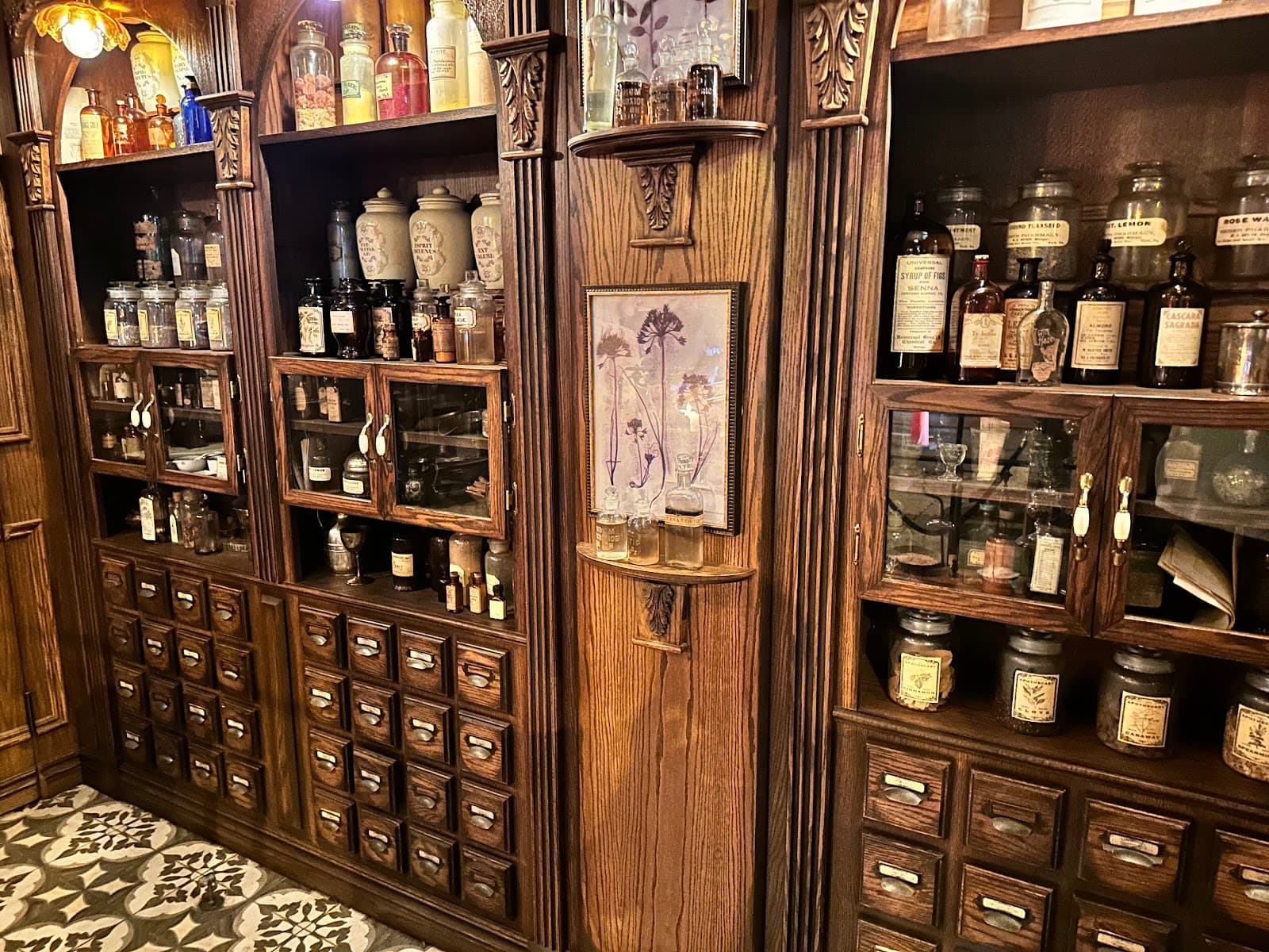 Vintage wooden shelves displaying bottles and apothecary jars in a cocktail bar interior in Toronto