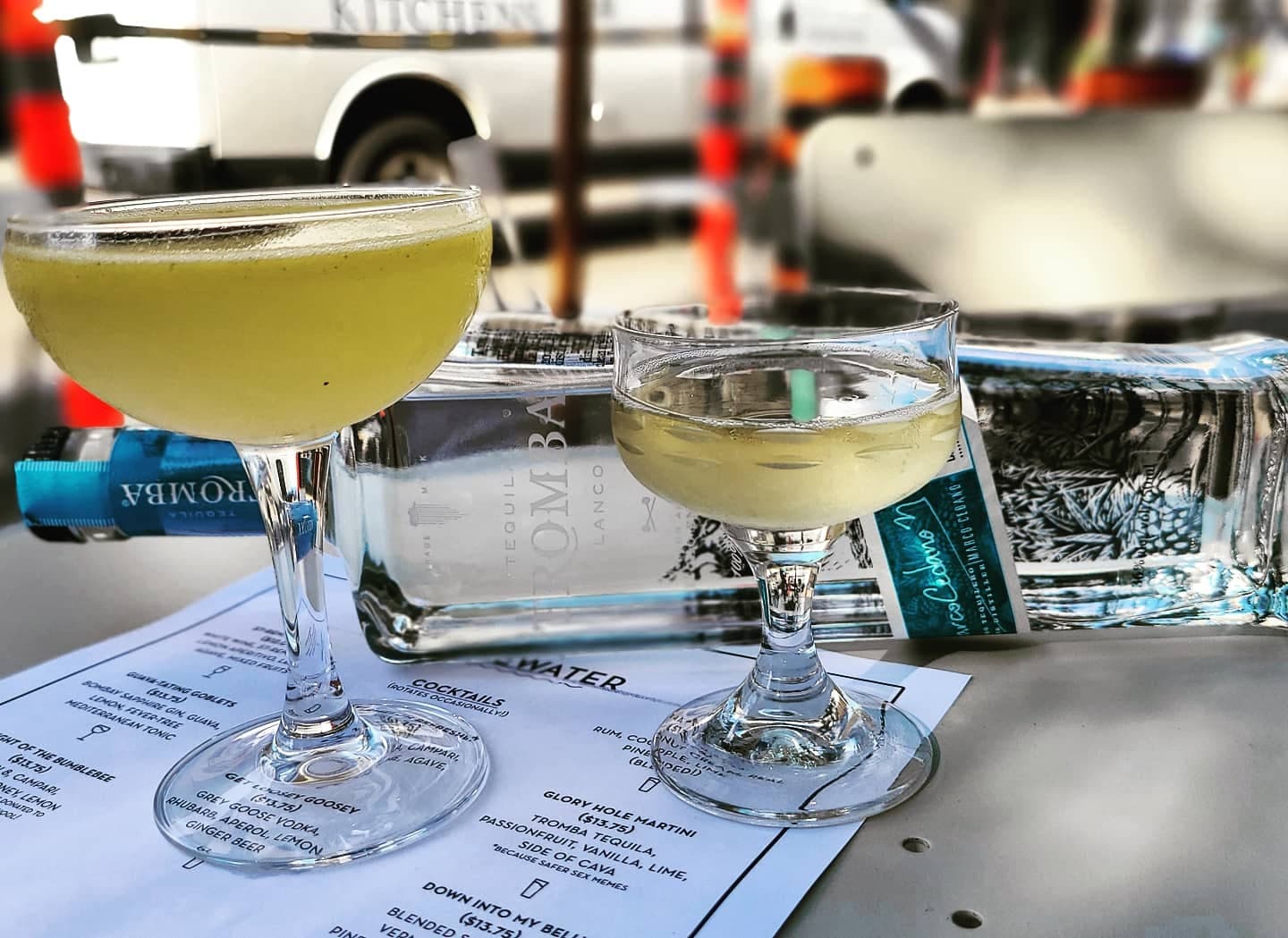 Two cocktails on a table with Tromba tequila bottle and a menu in the background in Toronto