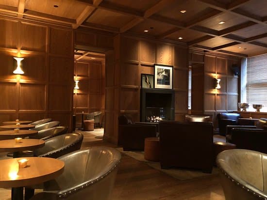 Warm, intimate interior with leather seating and wood paneling. in London