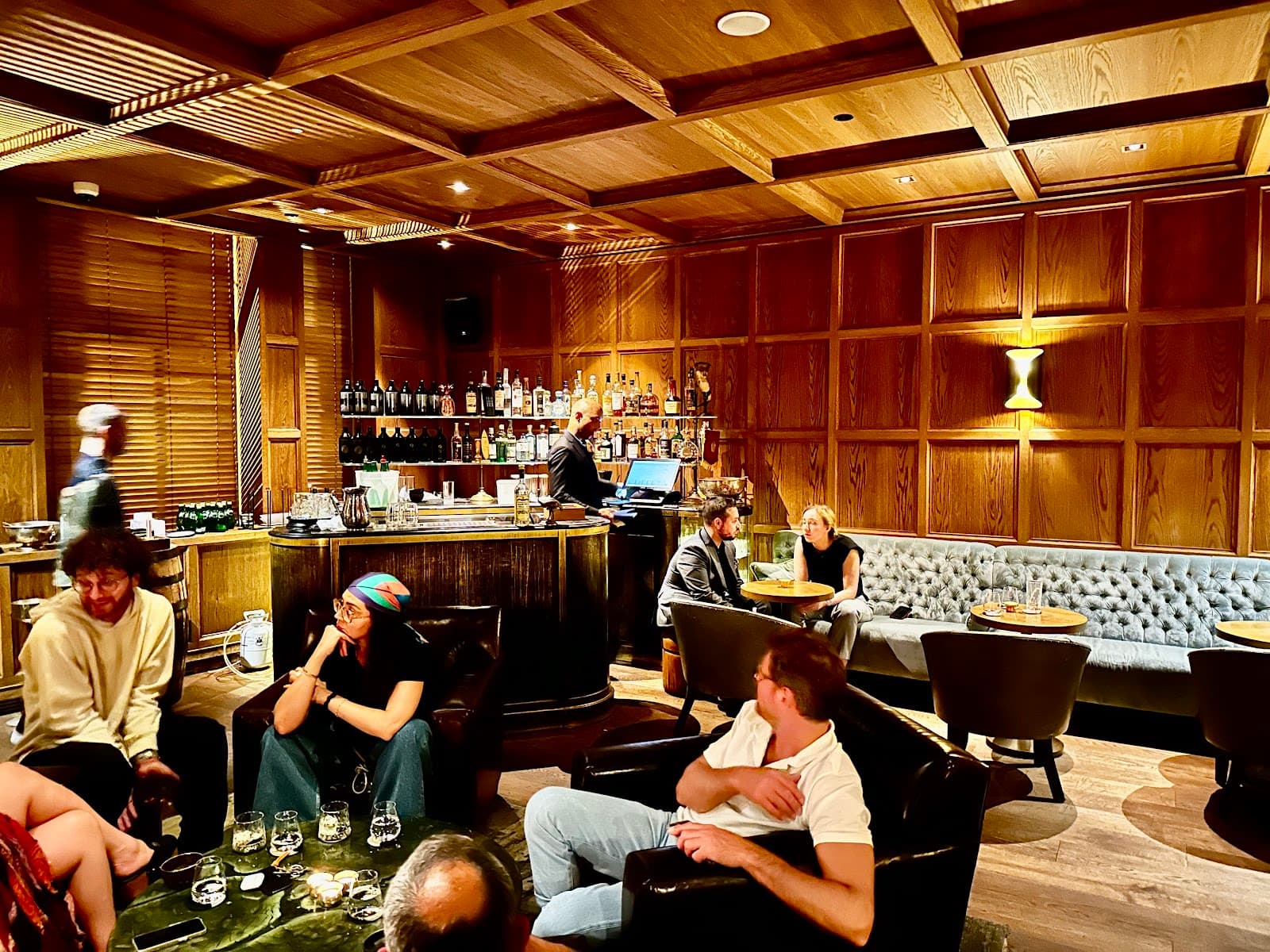 Warm-lit interior showcasing seating area and bar counter in a cocktail venue