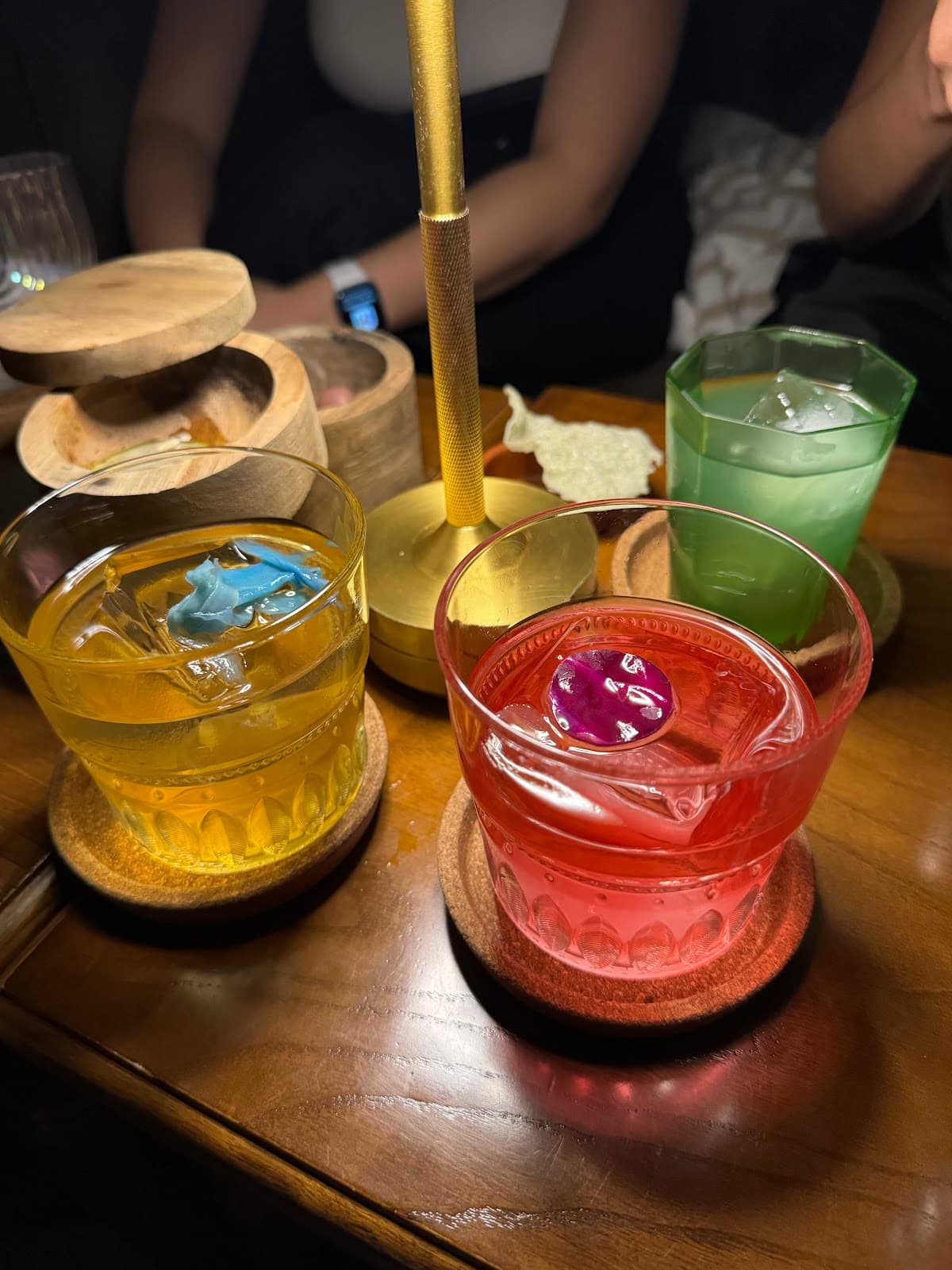 Colorful cocktails on a wooden table under warm lighting in Lisboa