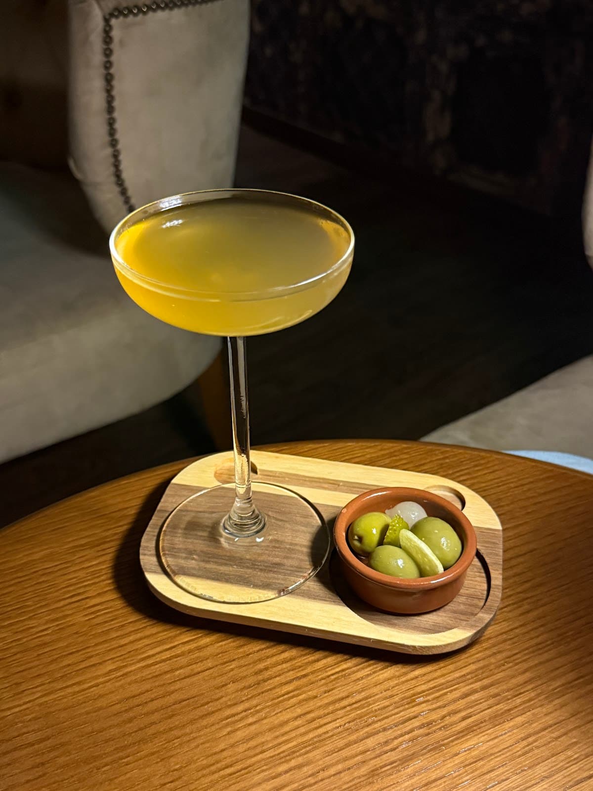 Cocktail on wooden tray with olives in a premium bar setting in Lisboa