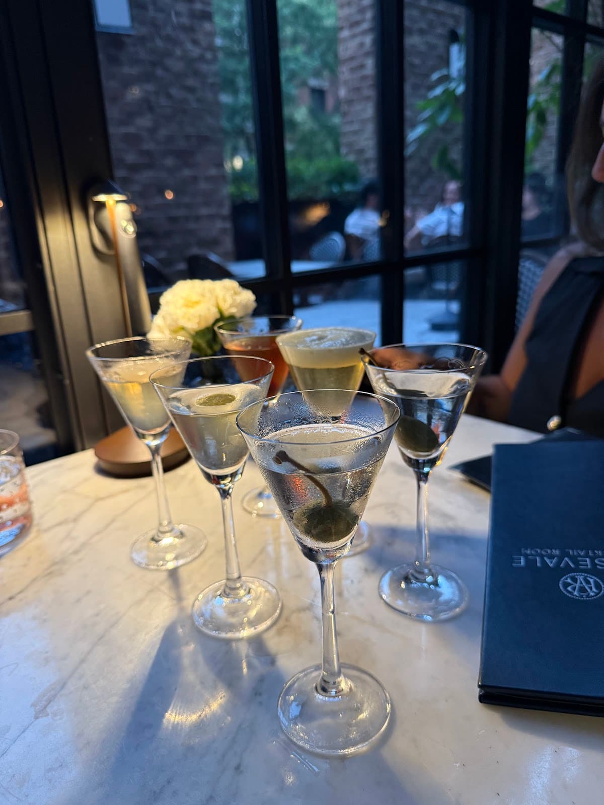 Assorted cocktails on marble table with flowers and menu in New York