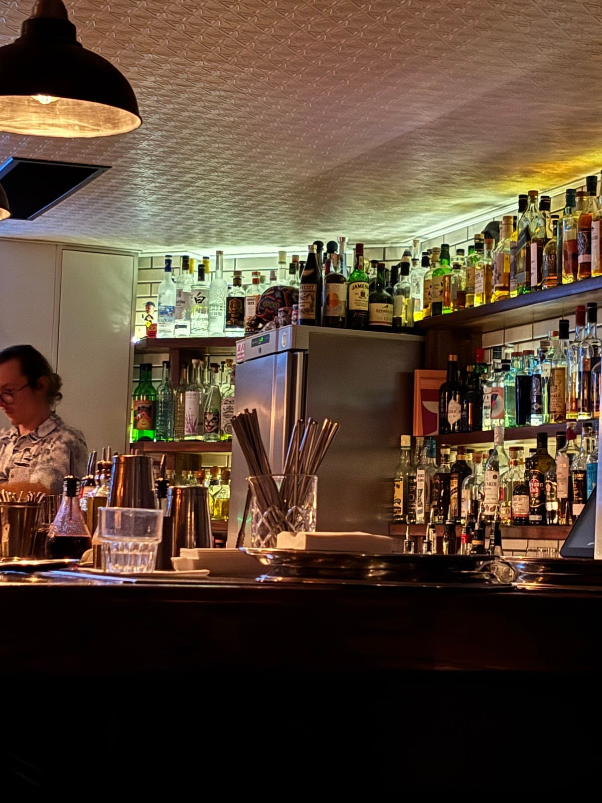 Well-stocked bar counter with dim lighting and assorted liquor bottles in London