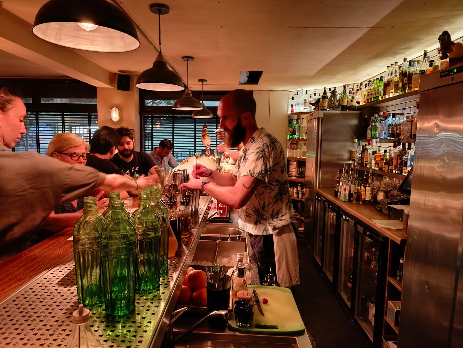Bartender serving drinks at a lively cocktail bar