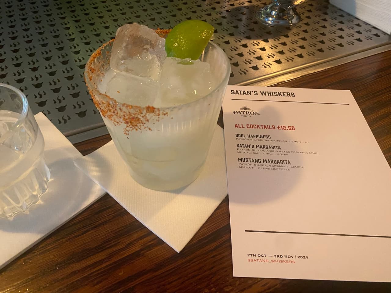Cocktail with lime and menu at Satan's Whiskers bar in London
