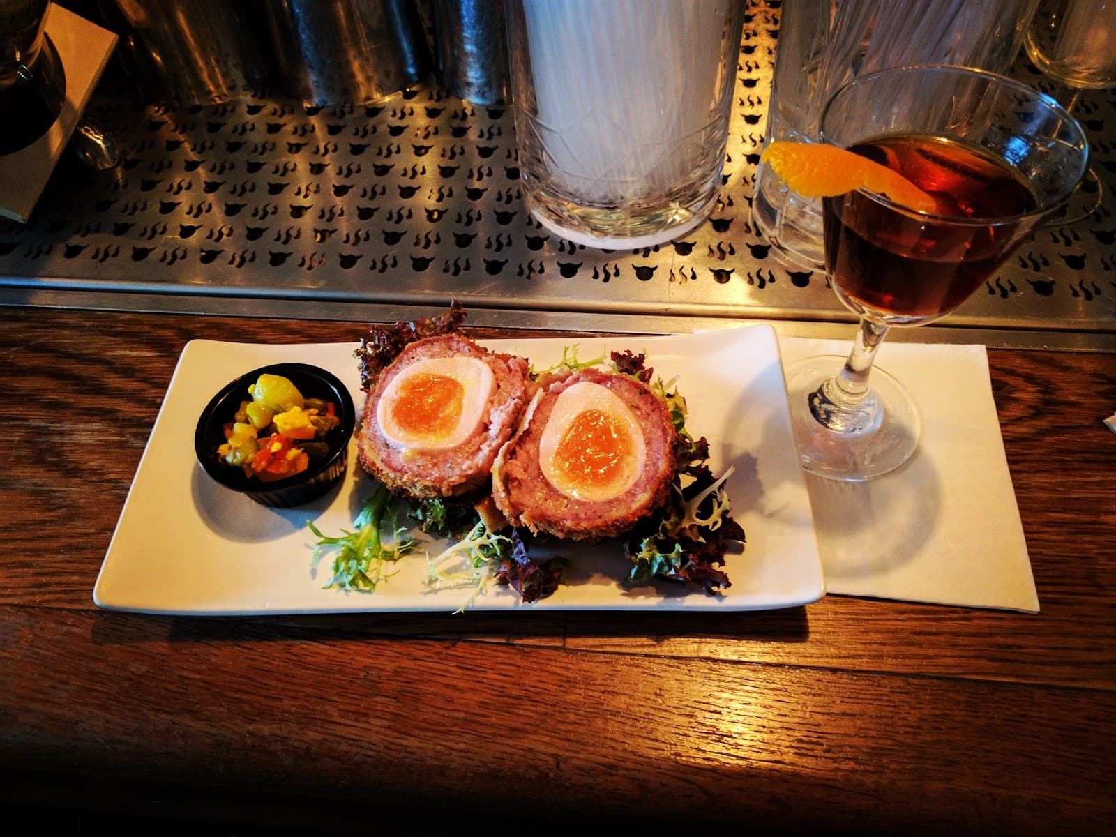 Cocktail and scotch egg served on a bar counter in London