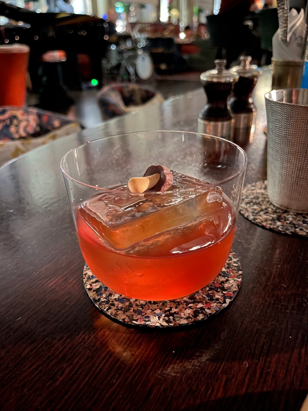 Close-up of a vibrant cocktail on a bar with a lounge background in London
