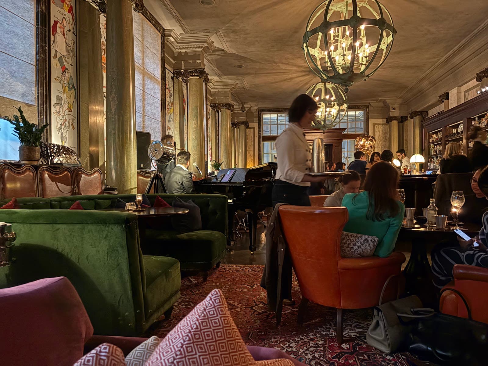 Elegant bar interior with velvet seating and chandeliers in London