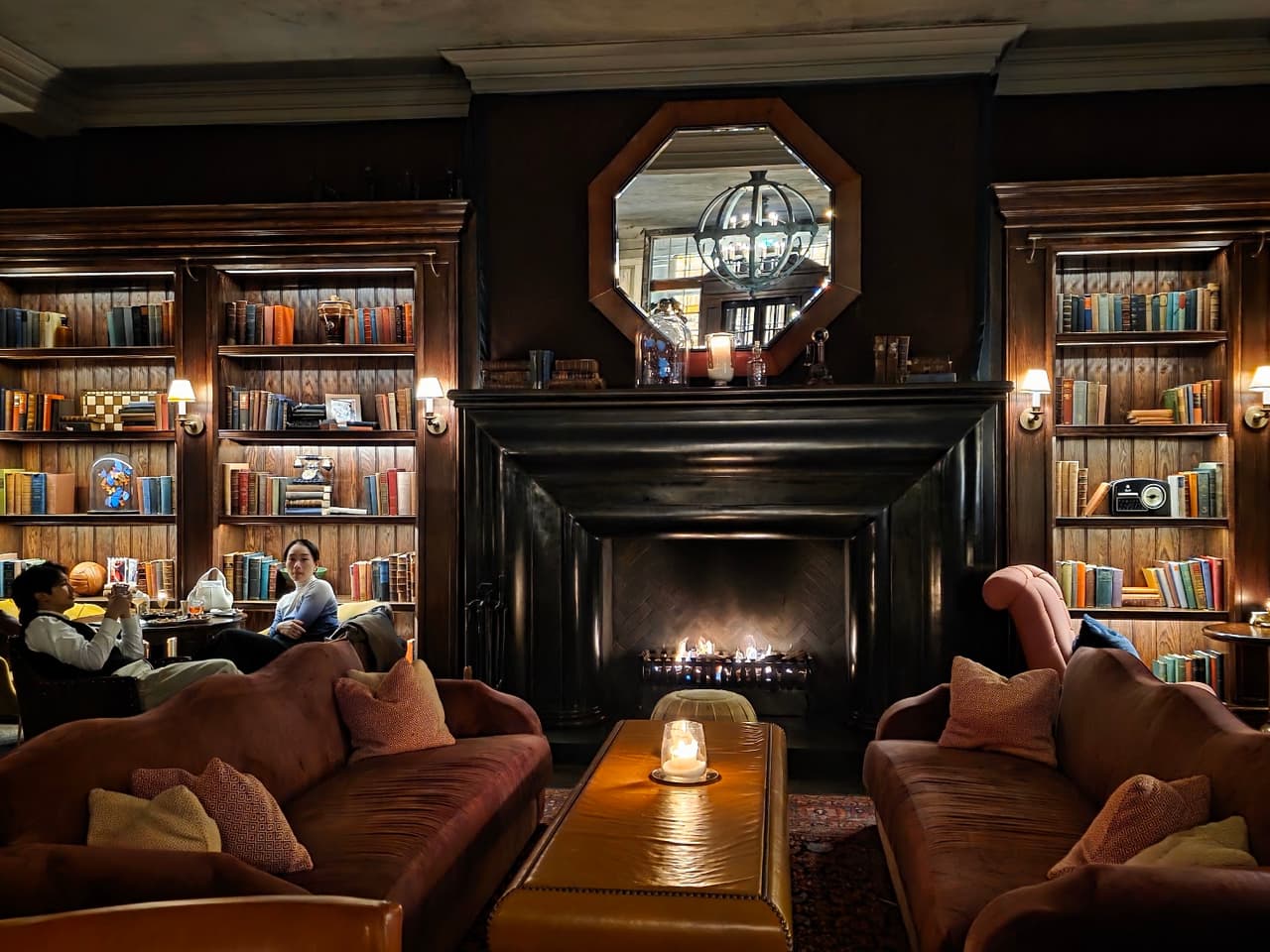 Cozy lounge area with fireplace, bookcases, and comfortable seating. in London