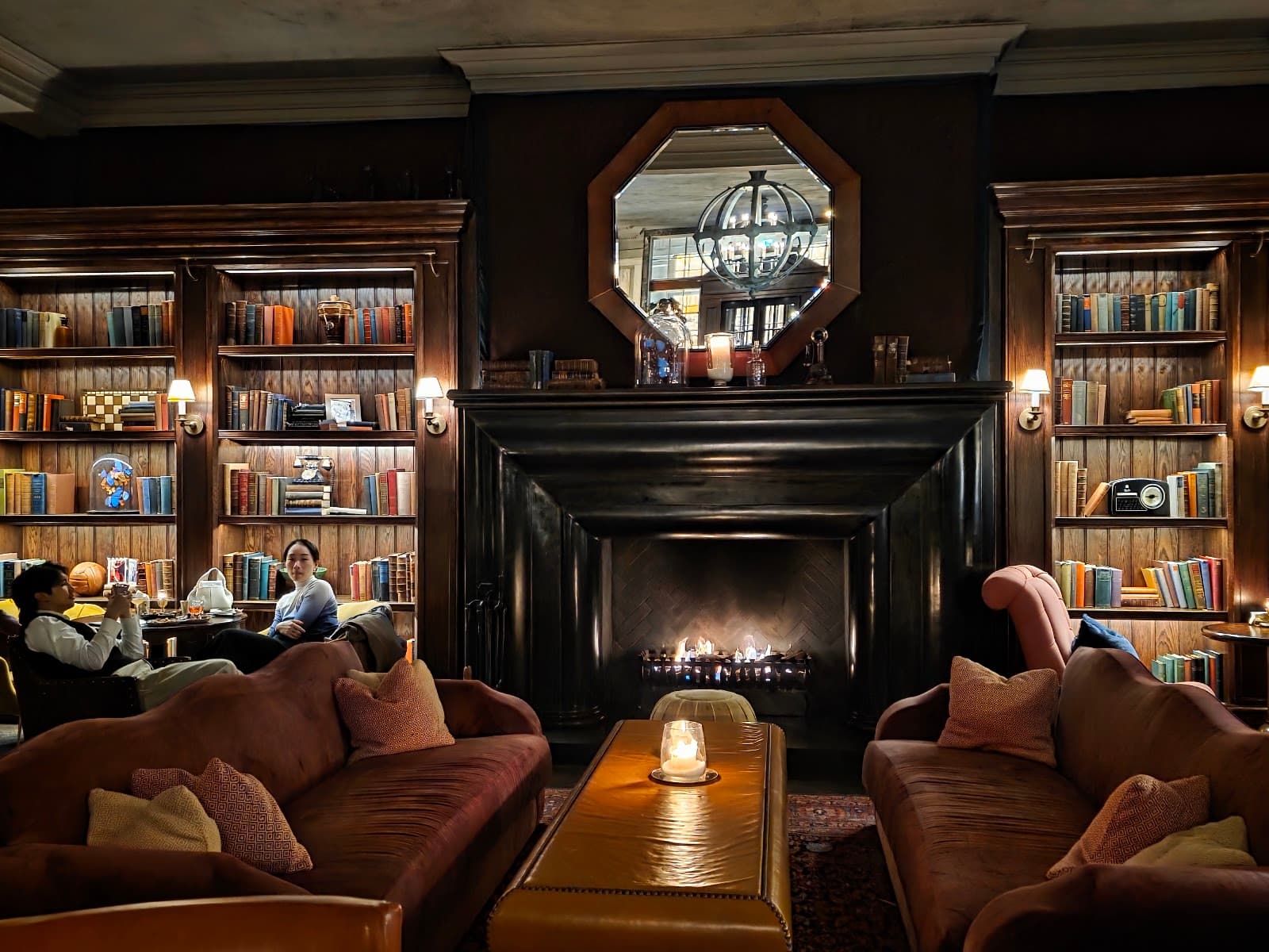 Cozy lounge area with fireplace, bookcases, and comfortable seating. in London