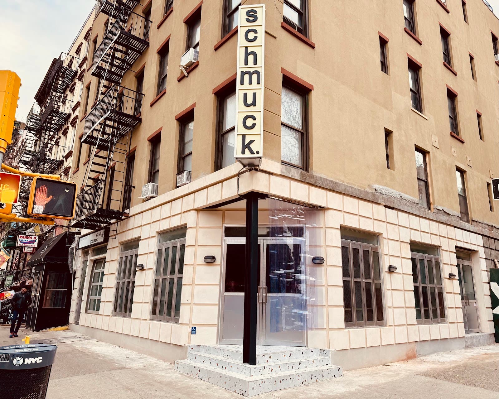 Exterior of bar named 'Schmuck' on a city street corner in New York
