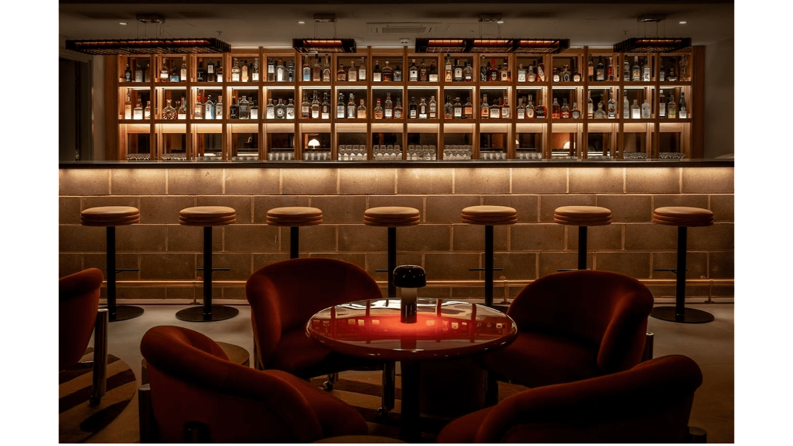 Stylish bar area with backlit shelves and modern seating