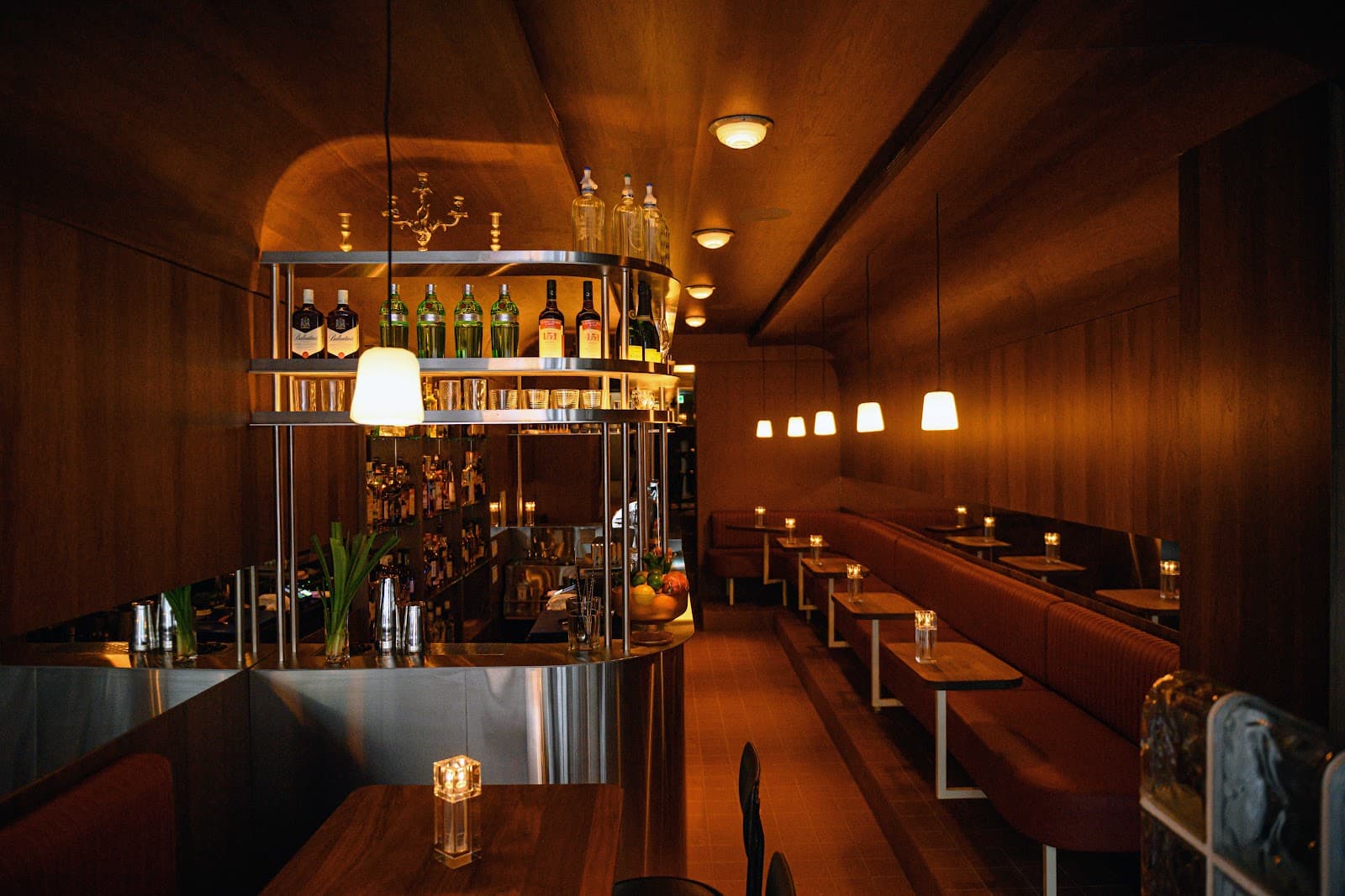 Cozy interior with wooden decor, booth seating, and a well-stocked bar