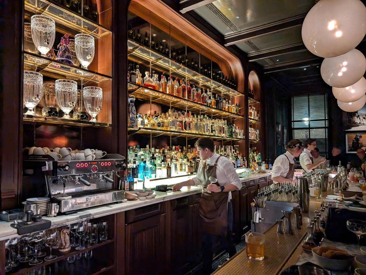 Stylish bar interior with bottles and bartenders in action in London