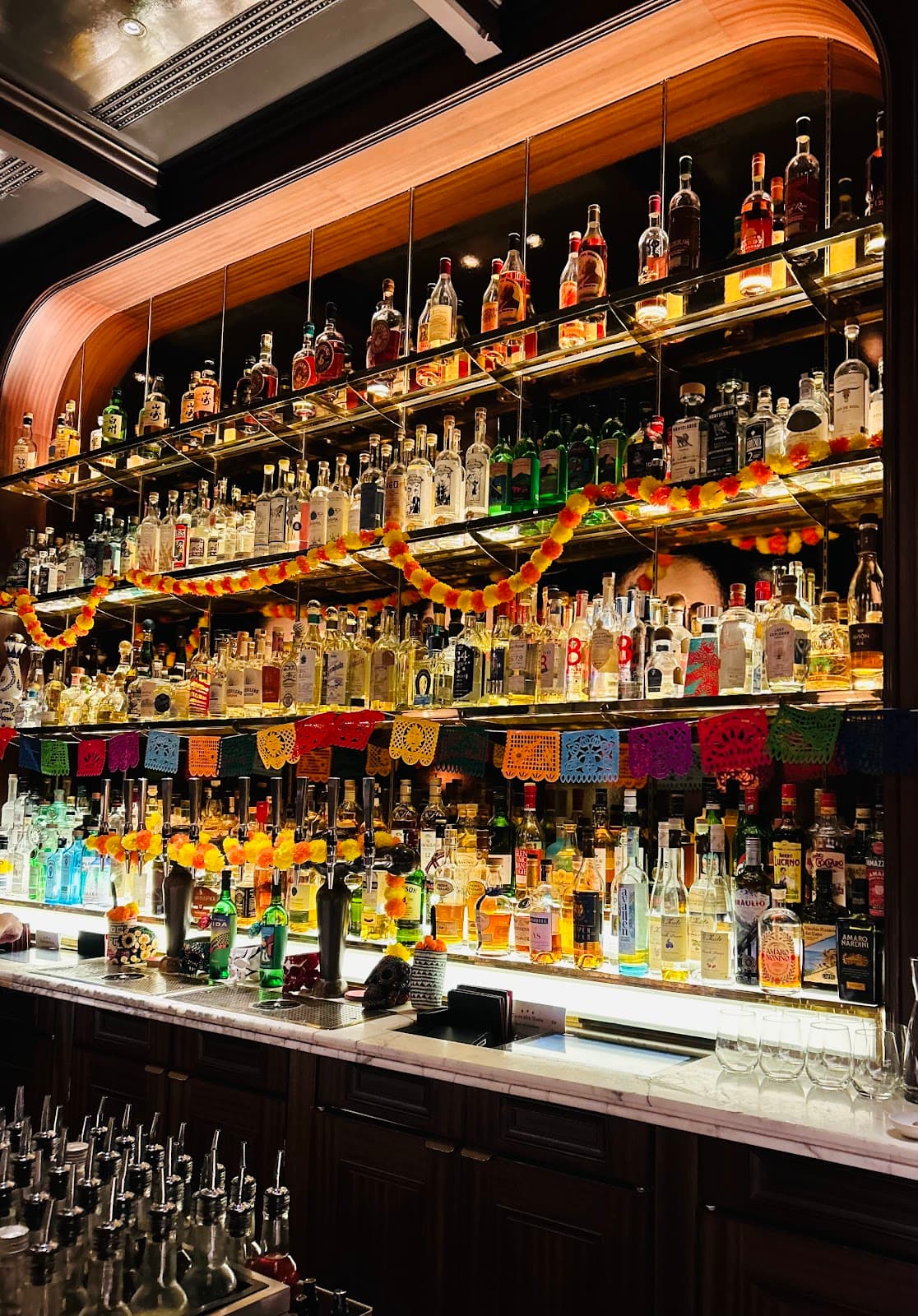Well-lit bar counter with colorful bottles and decorations in London