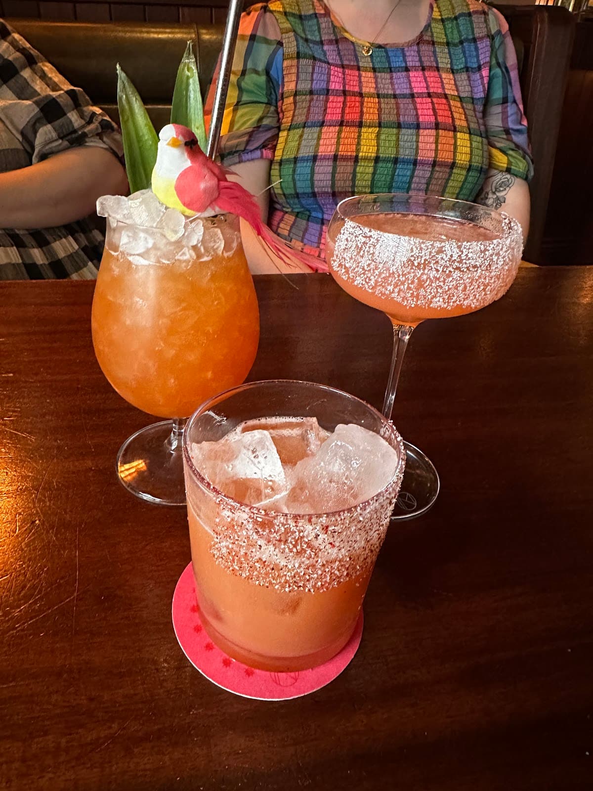 Assorted cocktails with garnishes on a wooden table in London