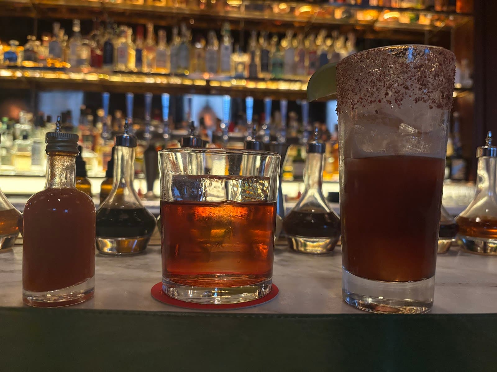 Close-up of cocktails on a bar counter with bottles in the background in London