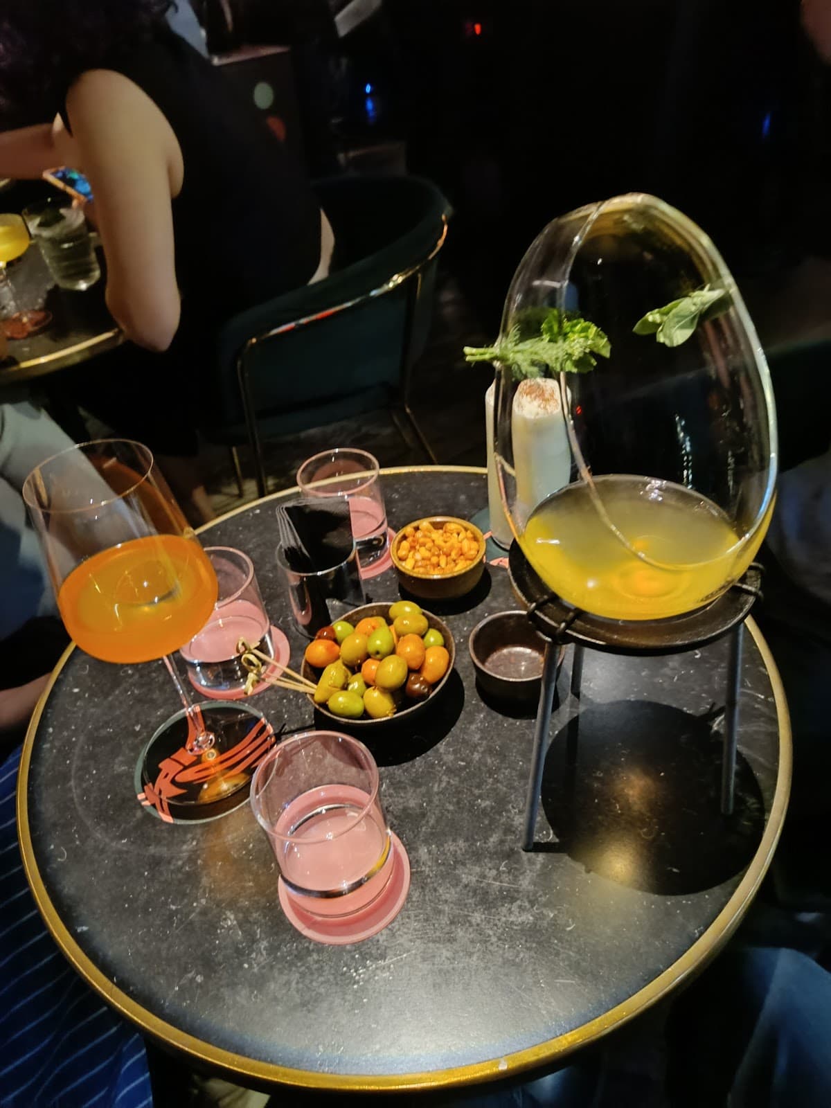 Elegant table setup with cocktails and snacks in a dimly lit bar in Barcelona
