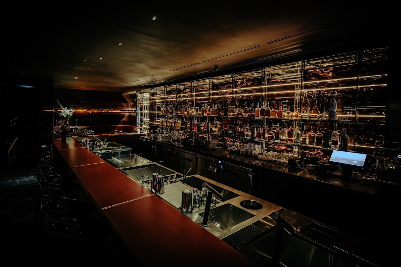 Elegantly lit bar with backlit shelves and a sleek counter