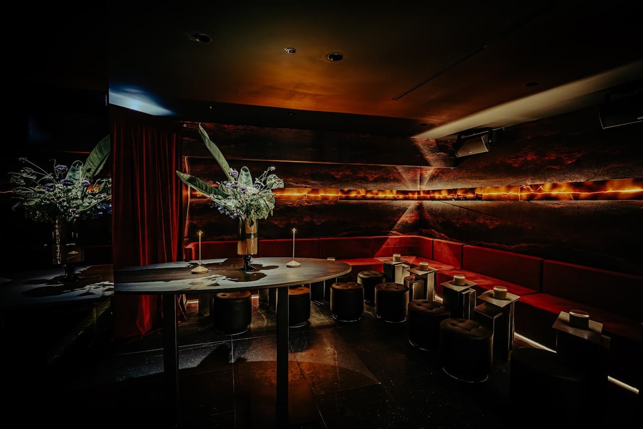 Dimly lit cocktail bar interior with decorative lighting and seating in Toronto