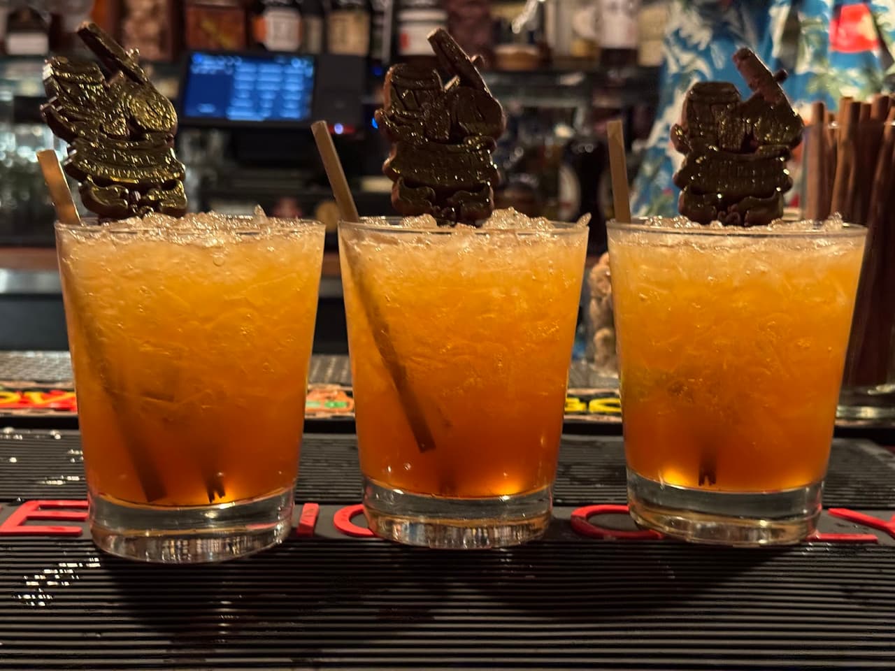 Three cocktails with ice and decorative stirrers on a bar counter in San Francisco