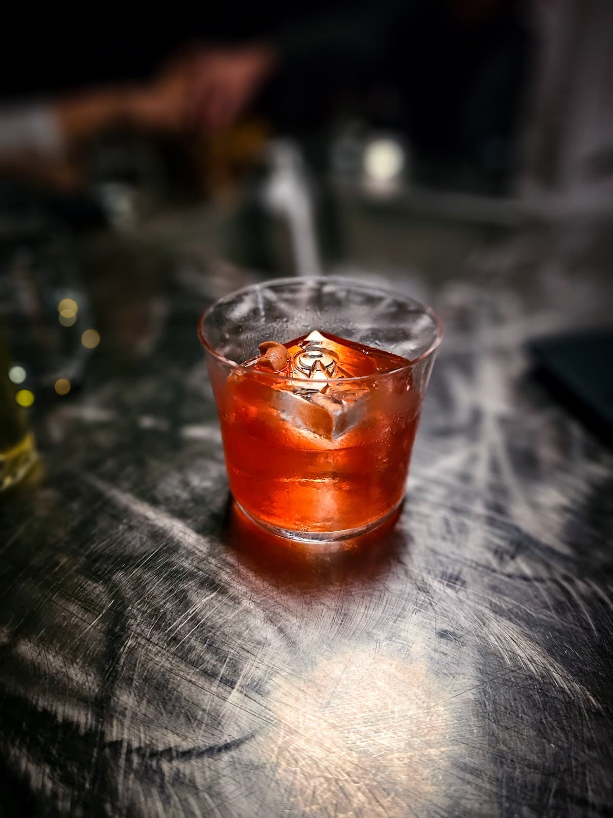 Close-up of a cocktail on a metallic surface with ice cubes in London