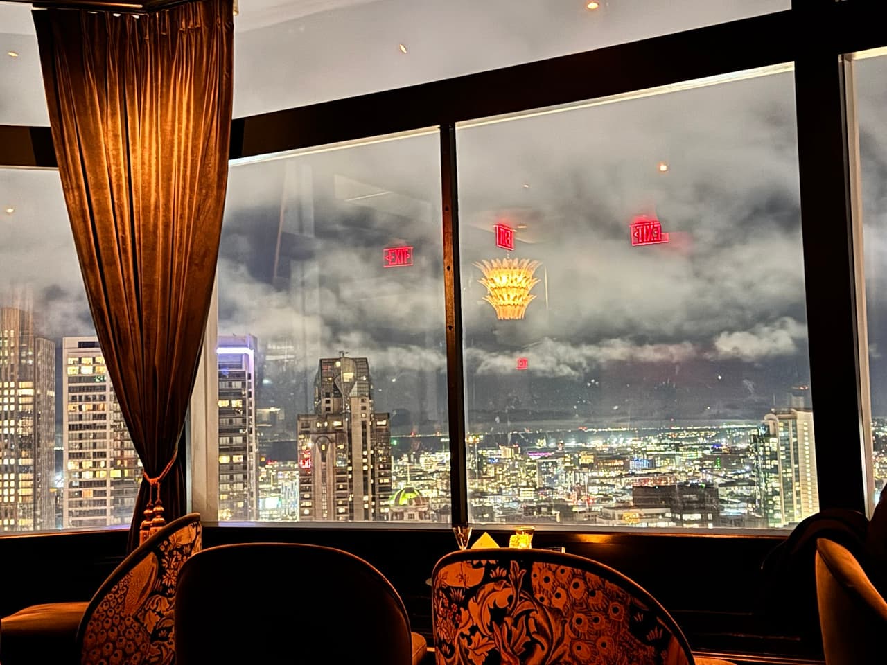Evening view from a high-rise cocktail bar with city skyline in the background in San Francisco