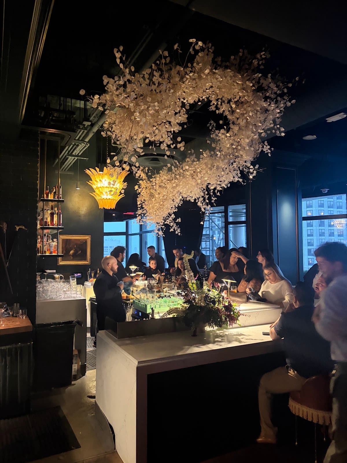 Chic bar interior with people socializing and decorative ceiling blossoms in San Francisco
