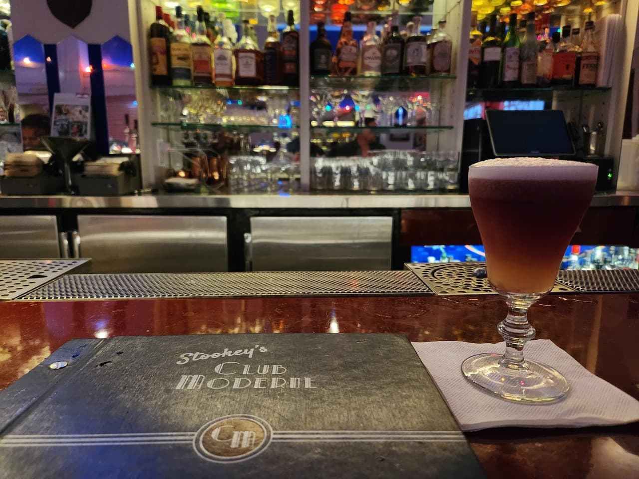Bar counter with cocktail glass and menu at Stookey's Club Moderne. in San Francisco