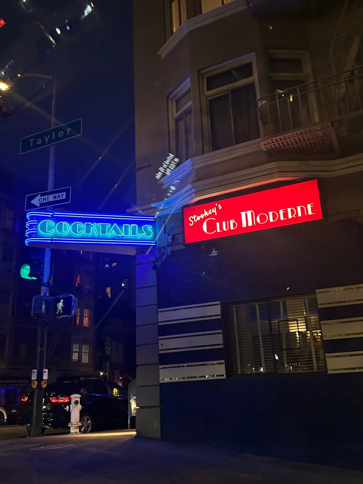 Exterior view of Stookey's Club Moderne with neon cocktail sign at night in San Francisco