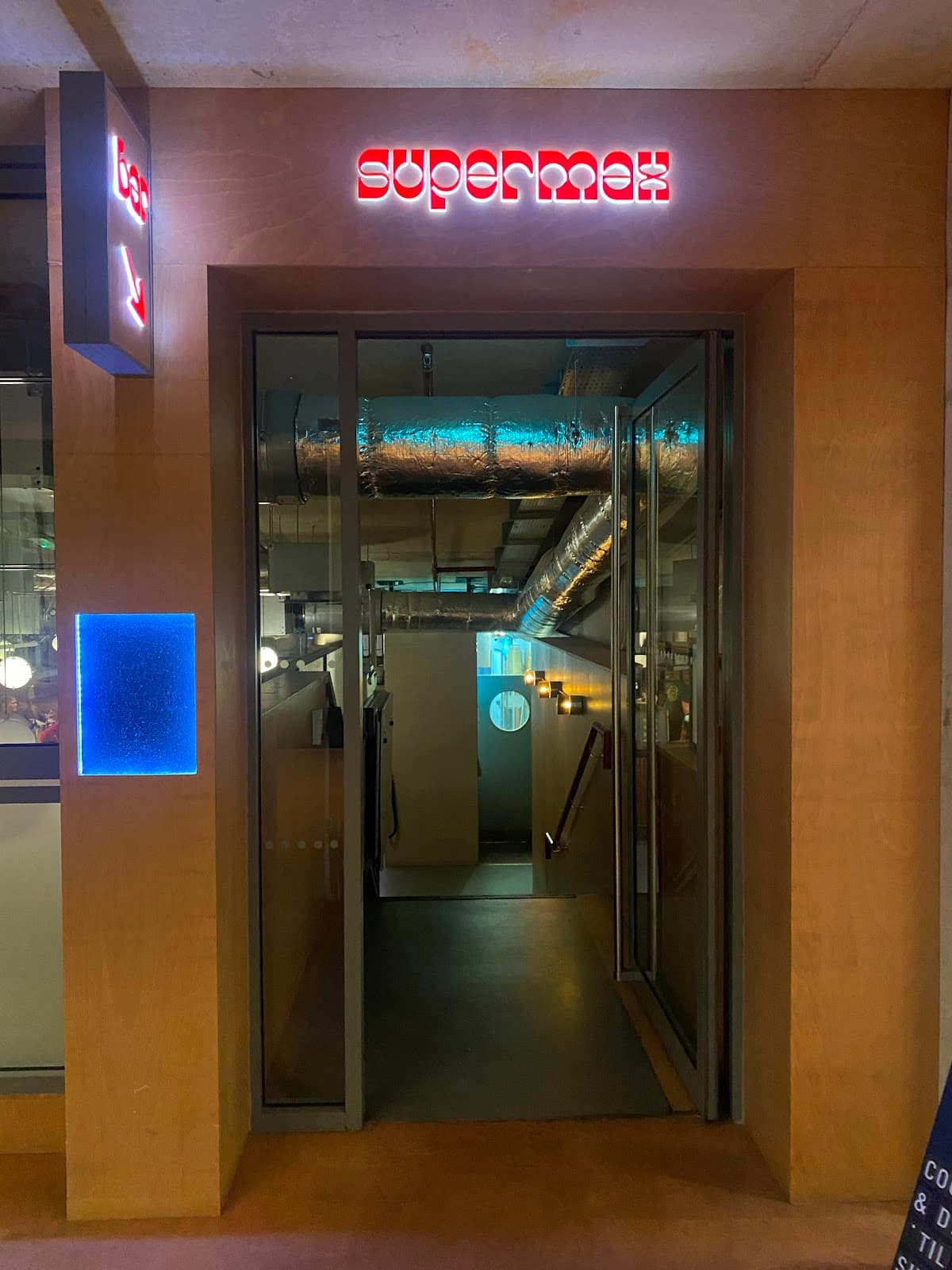 Entrance to Supermax with illuminated red sign in London