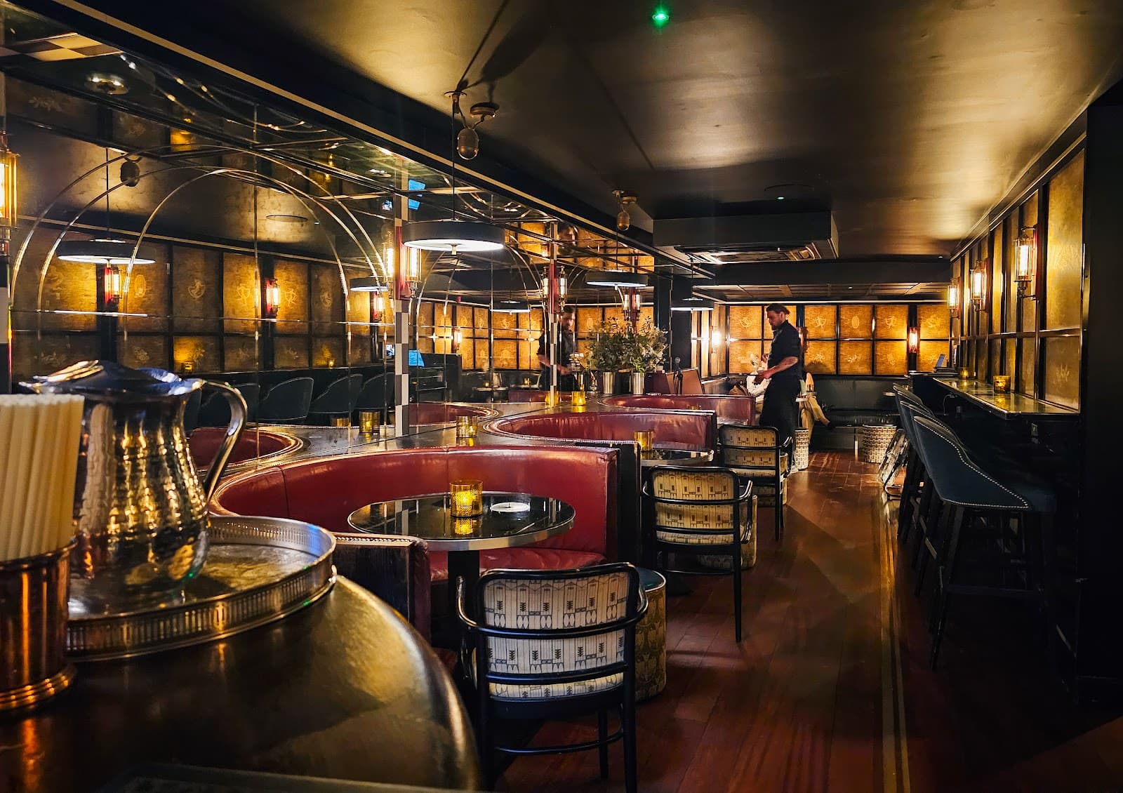 Luxurious interior with round booths and warm lighting in a cocktail bar in London