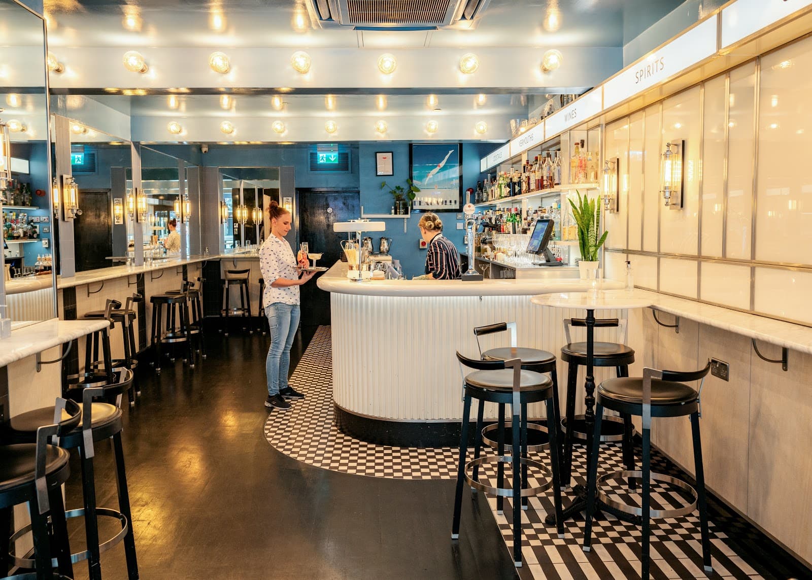 Bright modern bar interior with checkered floor and lighted ceiling