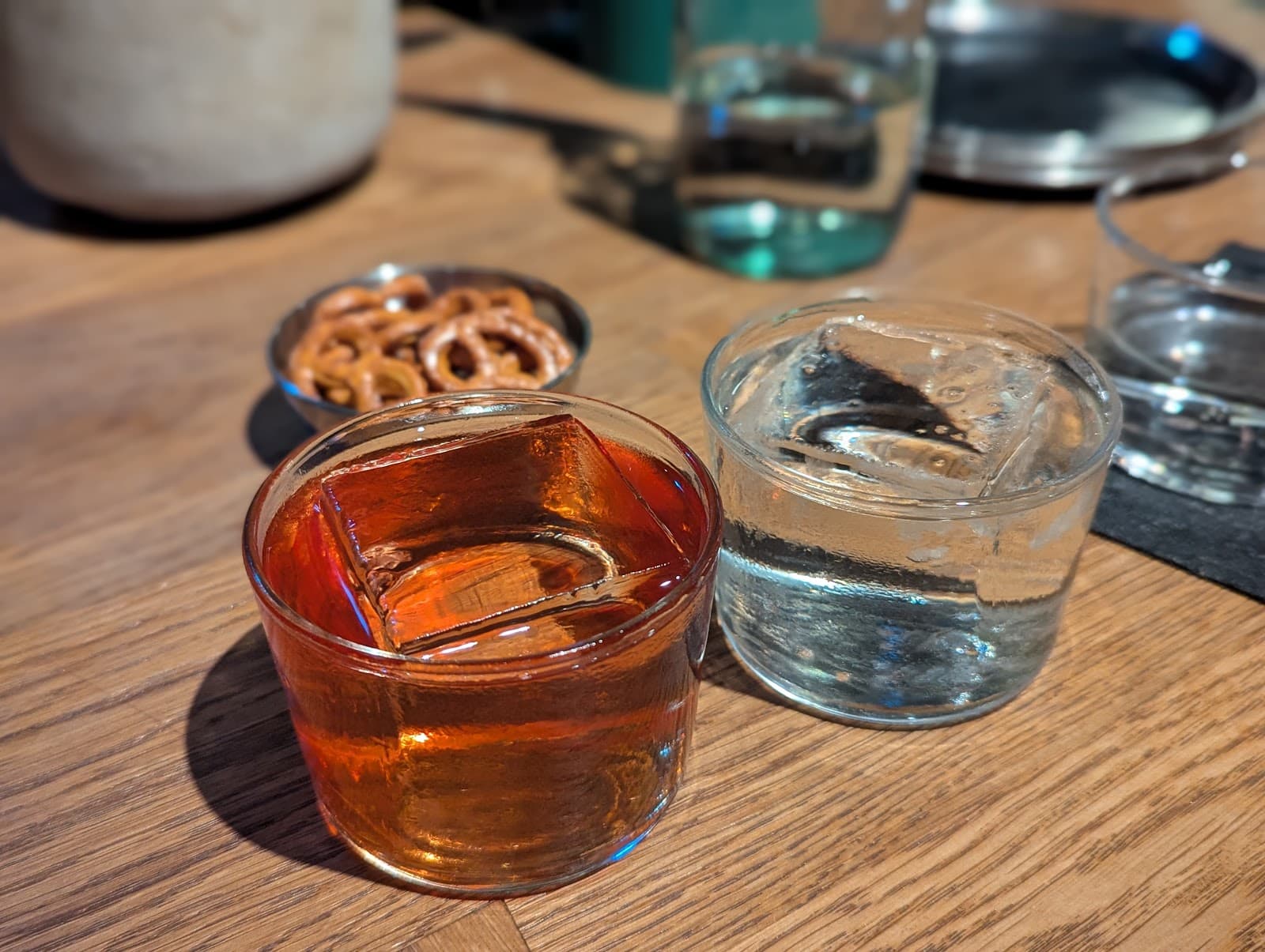Close-up of cocktails on a wooden table with pretzels in the background in London