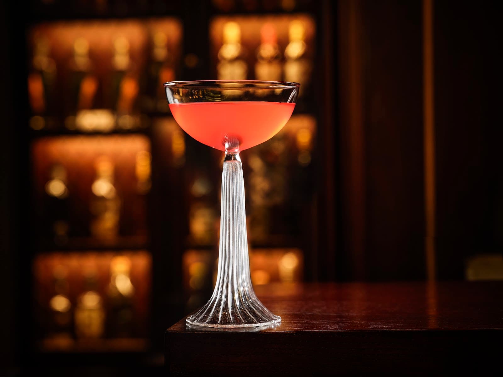 Elegant cocktail glass with red drink on a bar counter in London