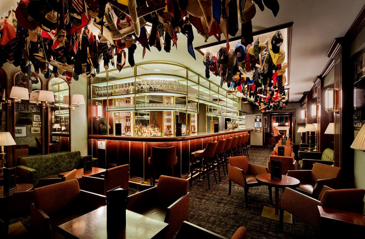 Stylish bar interior with hanging ties and cushioned seating