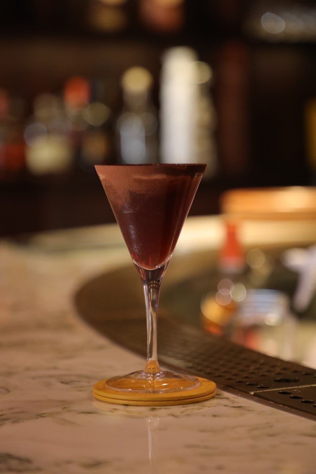 Elegant cocktail in a martini glass on a marble bar counter in London