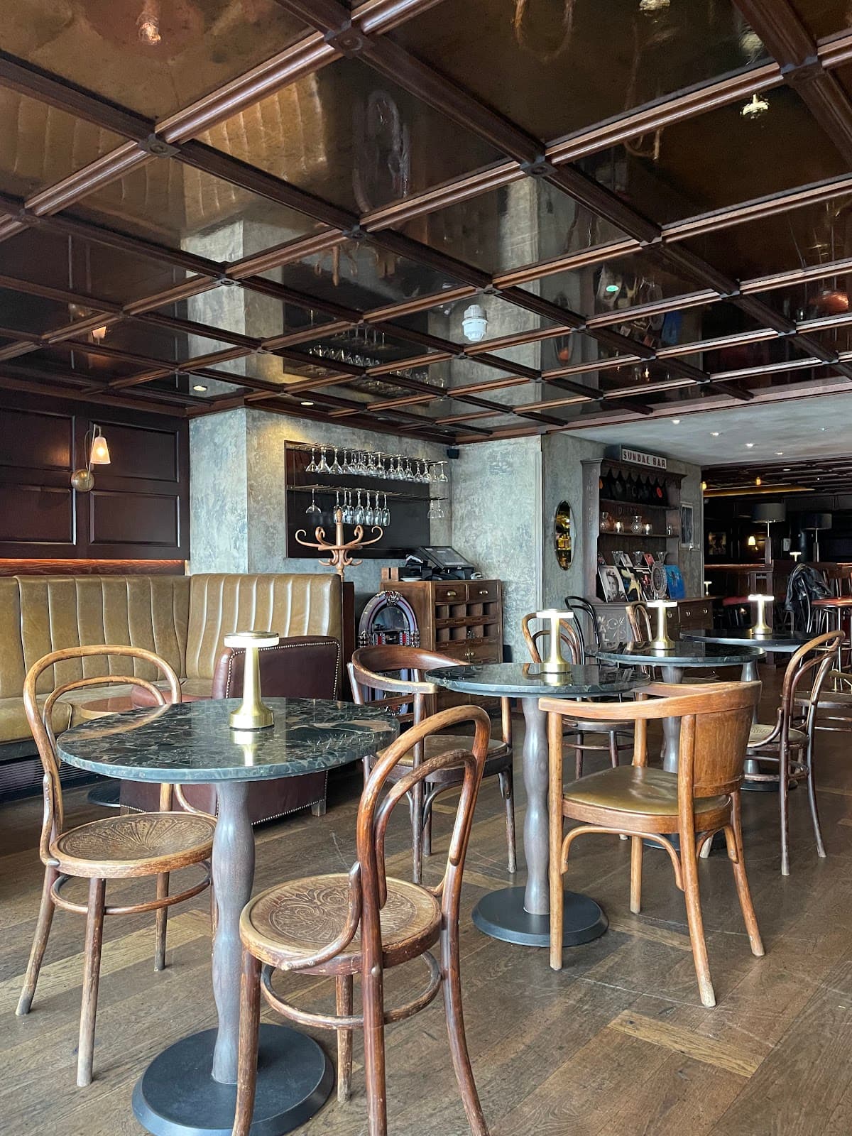 Chic interior with wooden tables and chairs in a cocktail bar setting in London