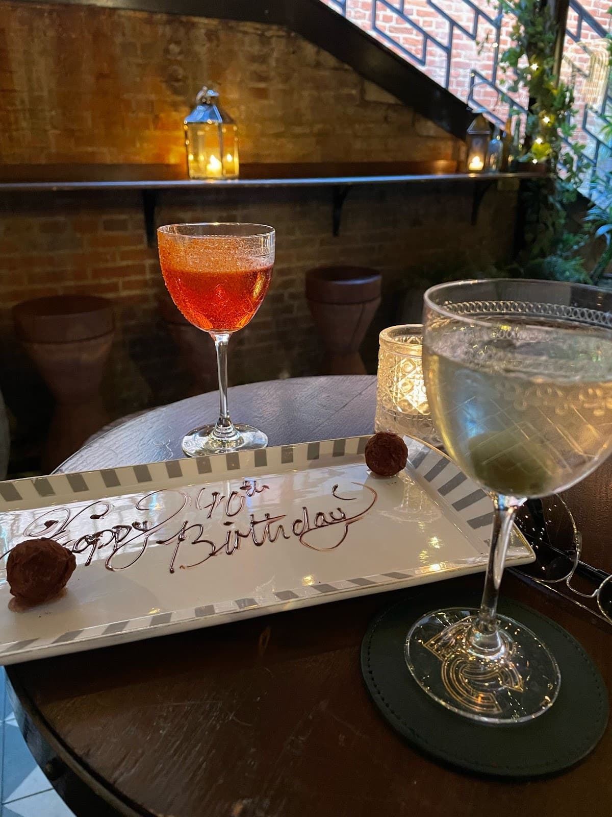 Cozy ambiance with cocktails, candles, and exposed brick wall in London