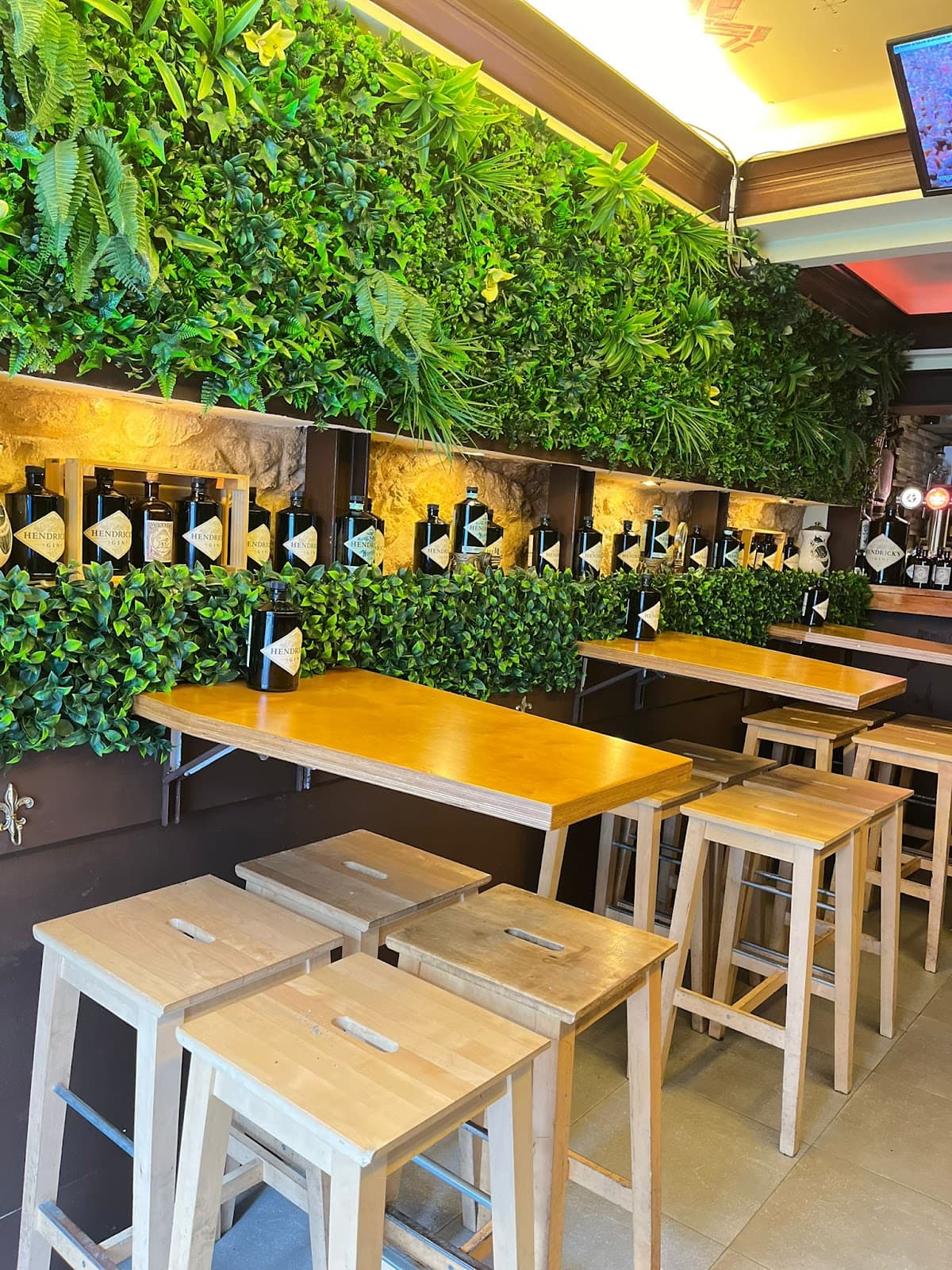 Interior with green wall and wooden tables at a cocktail bar