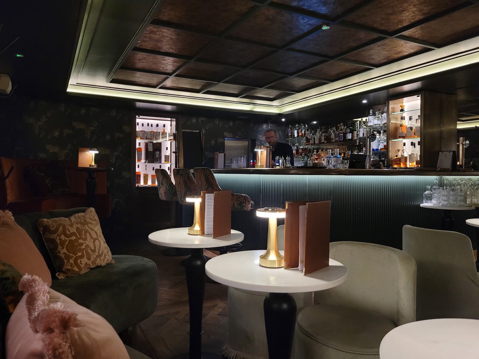 Elegant bar interior with a variety of spirits and cozy seating in Edinburgh