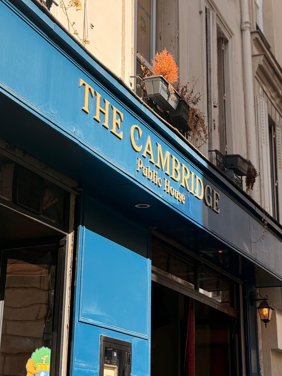Exterior of The Cambridge Public House with blue signage in Paris