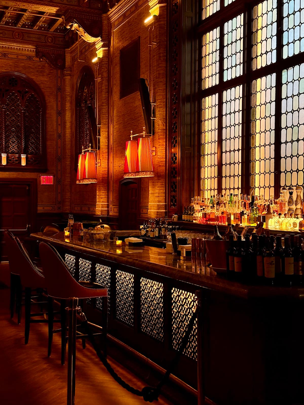 Elegant bar interior with ornate decor and lit bottles in New York
