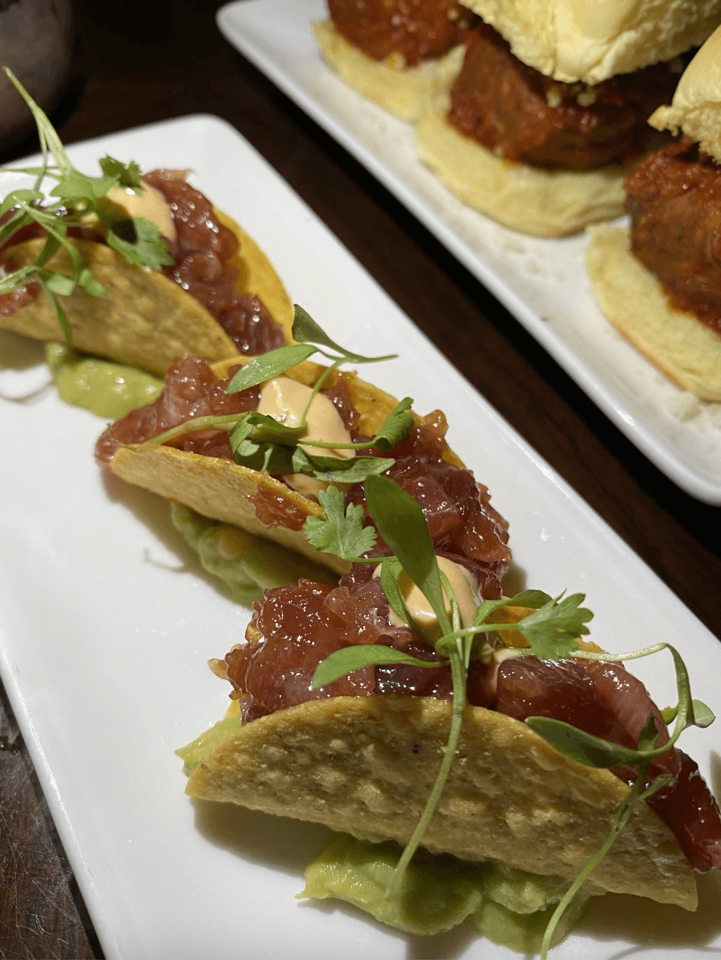 Close-up of gourmet tacos with microgreens on a white plate in New York