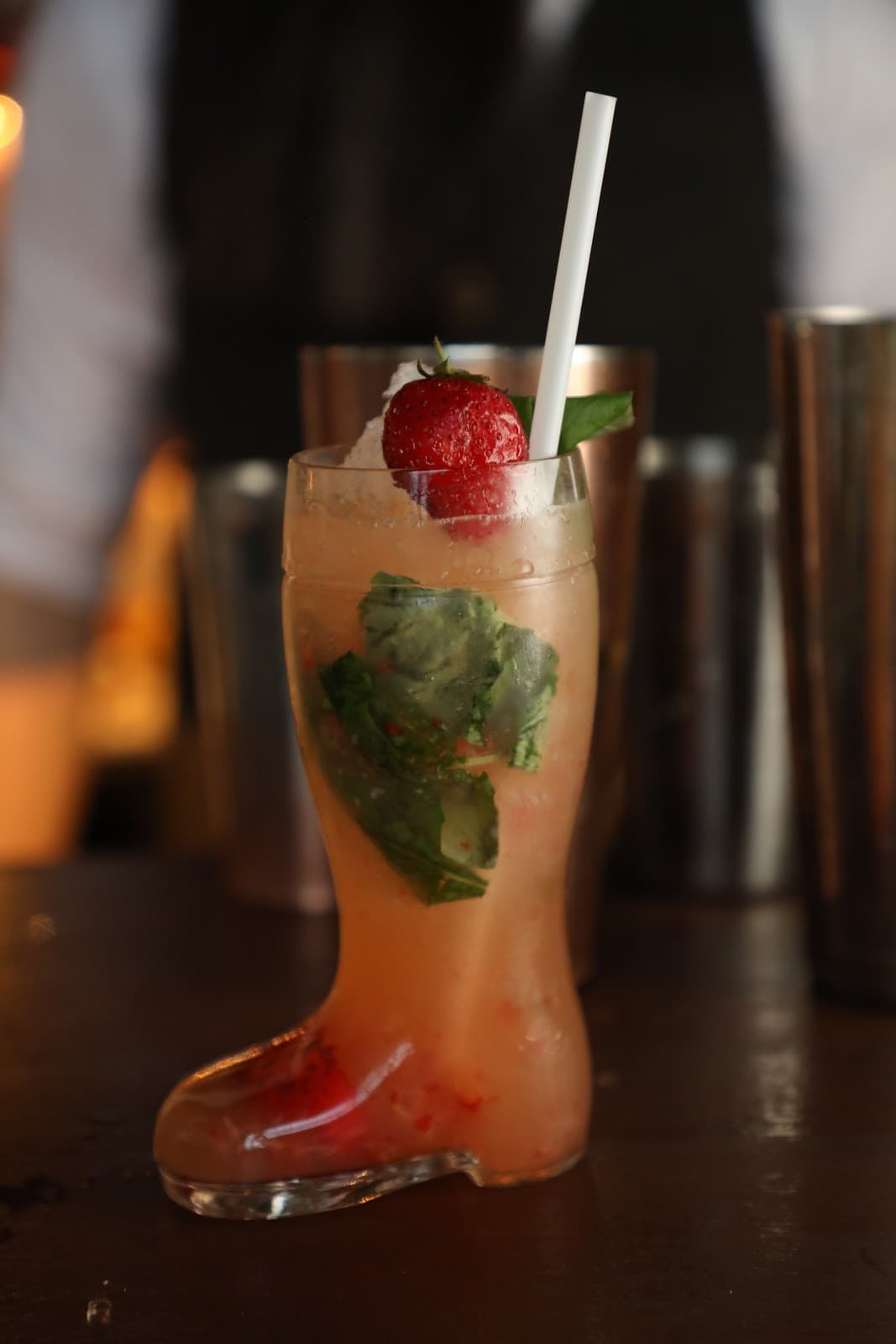 Creative cocktail served in a boot-shaped glass with strawberry and mint garnish in Edinburgh