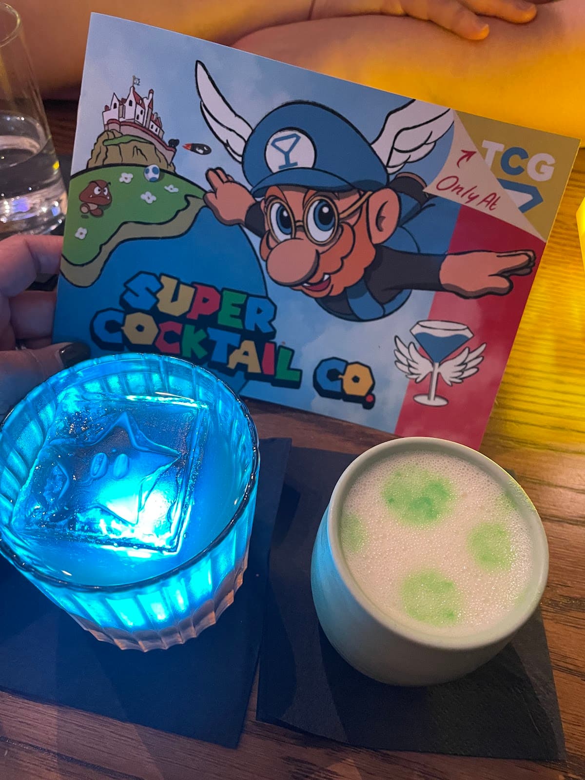 Colorful cocktails with a themed card on a wooden table in Edinburgh