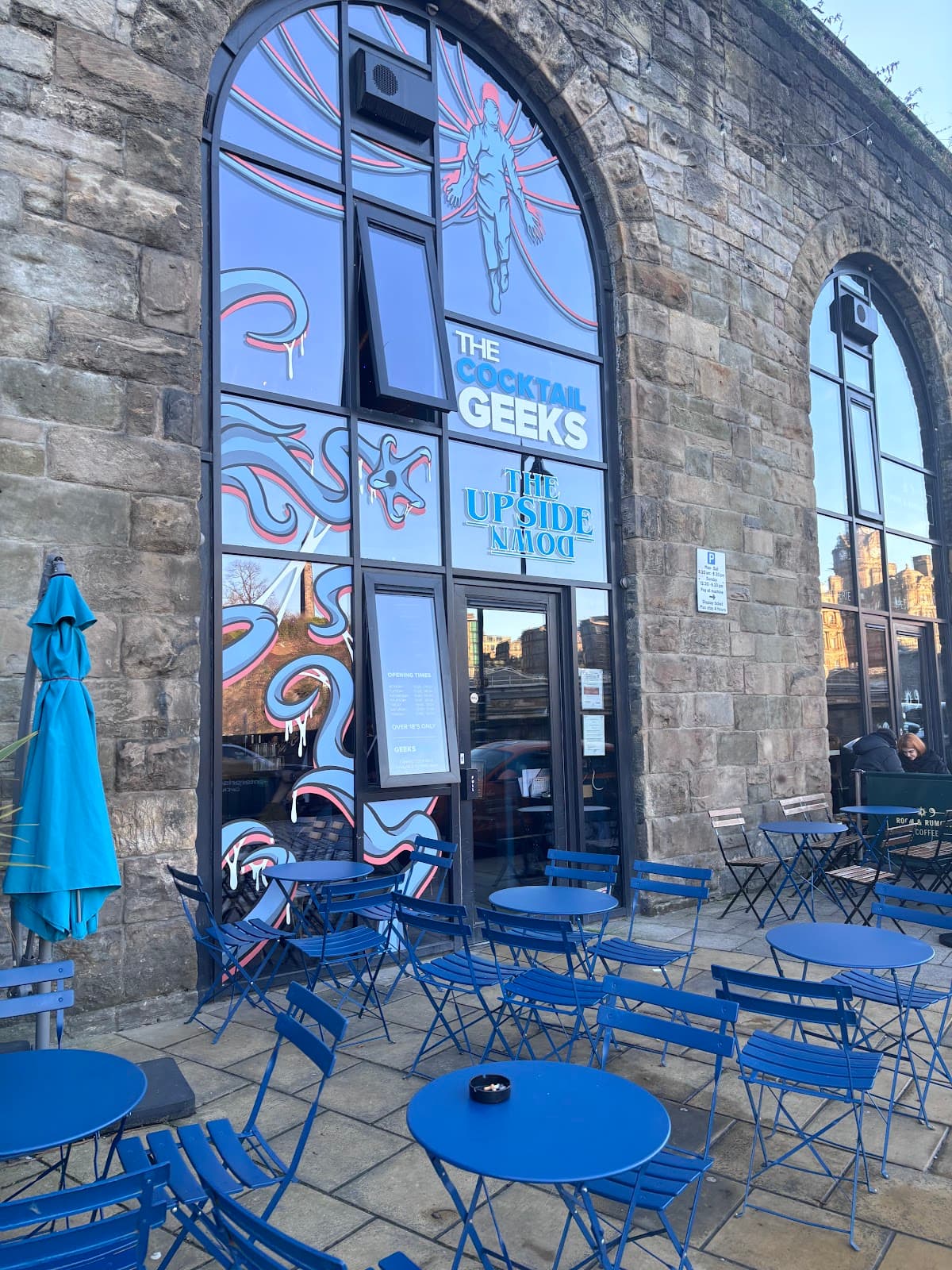 Exterior view of The Cocktail Geeks with blue outdoor seating in Edinburgh