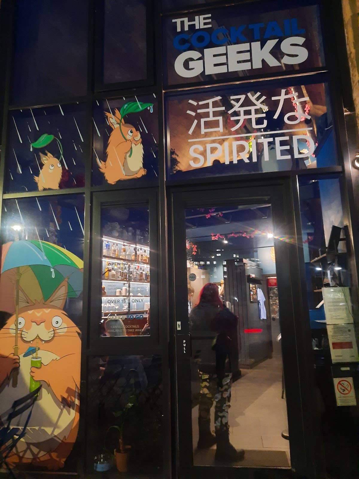 Entrance of The Cocktail Geeks bar, featuring cartoon artwork on the window in Edinburgh
