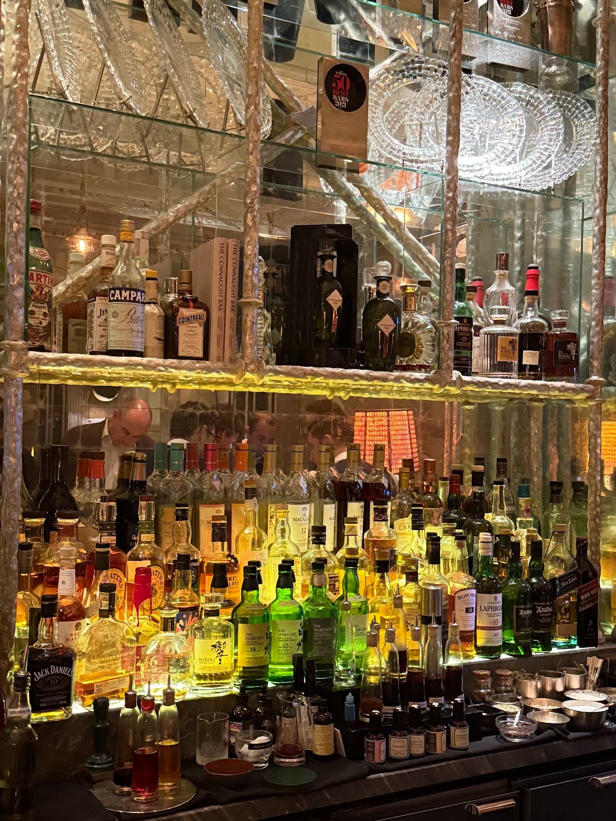 Close-up of a well-stocked bar with various bottles and glassware in London
